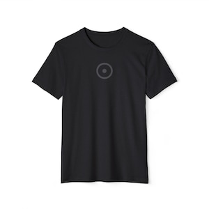 May include: Black crew neck t-shirt with a gray circle design on the chest. The design features a gray circle with a smaller circle inside. The shirt is made of a soft material.