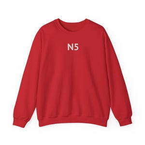 May include: A bright red sweatshirt with the white text "N5" centered on the chest. The long-sleeved crew neck top is made of a soft material and is suitable for casual wear. The simple design makes it versatile for various outfits.