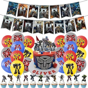 May include: A Transformers-themed birthday party featuring a red and grey cake decorated with the Autobot logo and the name "Oliver". The cake is surrounded by blue, red, yellow and grey balloons featuring Transformers characters. A banner with the words "Happy Birthday" is strung above the cake.