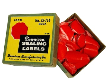 May include: A vintage box of Dennison sealing labels. The box is yellow and green with the text "Dennison SEALING LABELS" and "FRAMINGHAM, MASS., U.S.A." printed on it. The box contains many red sealing labels.