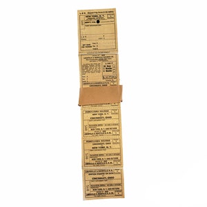 K&ouml;nnte beinhalten: Ein Stapel alter Zugtickets f&uuml;r Reisen zwischen New York, NY und Cincinnati, OH. Die Tickets sind auf braunem Papier mit schwarzer Tinte gedruckt und zeigen die Namen der Bahngesellschaften: Pennsylvania Railroad, New York Central Railroad und Louisville & Nashville Railroad.
