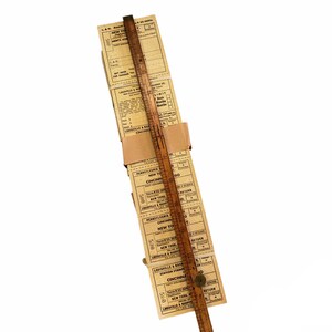K&ouml;nnte beinhalten: Ein Stapel alter Zugtickets mit Zielen wie New York, Cincinnati und Louisville. Die Tickets sind mit einem braunen Papierband zusammengehalten und ein Holzliniall liegt daneben.