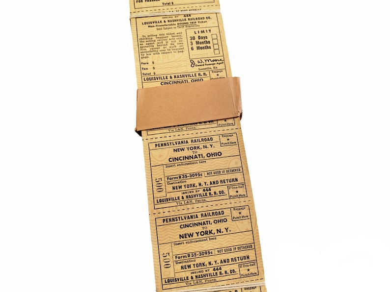 K&ouml;nnte beinhalten: Ein Stapel alter Zugtickets f&uuml;r Reisen zwischen New York, NY und Cincinnati, Ohio mit der Pennsylvania Railroad. Die Tickets sind datiert und haben eine G&uuml;ltigkeit von 30 Tagen oder 3 Monaten. Die Tickets sind braun und haben schwarzen Text.