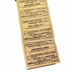 K&ouml;nnte beinhalten: Ein Stapel alter Zugtickets f&uuml;r die Reise von Cincinnati, Ohio nach New York, New York. Die Tickets wurden von der Louisville & Nashville Railroad ausgestellt und sind aus dem Jahr 1935. Die Tickets sind in gutem Zustand und haben eine beige Farbe.
