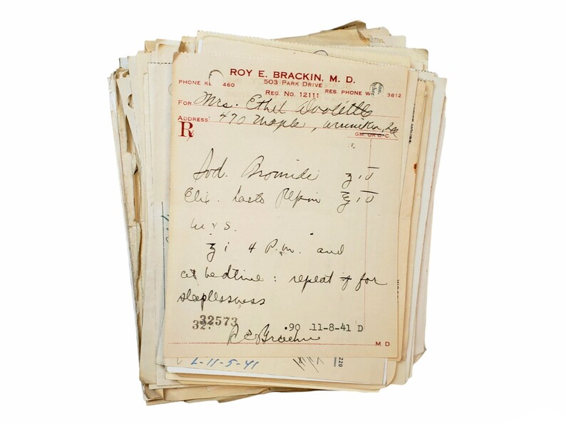 May include: A stack of old, yellowed papers with handwritten notes and a prescription for "Lod. Promise" with instructions to take "Clit lasts lepin 5/10" and "3 i 4 P.M. and at bedtime: repeat if for sleeplessness". The prescription is dated 11-8-41 and signed "R.E. Brackin, M.D."