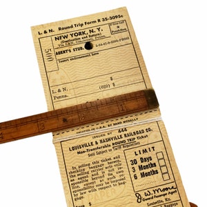 K&ouml;nnte beinhalten: Ein Vintage-Zugticket f&uuml;r eine Rundreise von der Louisville & Nashville Railroad Co. nach New York, N.Y. Das Ticket ist datiert auf den 2-24-41-0-2000-PB303 und ist nicht &uuml;bertragbar. Das Ticket hat eine G&uuml;ltigkeit von 30 Tagen, 3 Monaten oder 6 Monaten. Das Ticket ist von J.W. Moore, General Passenger Agent, unterzeichnet.