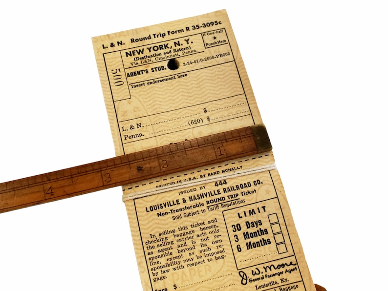 K&ouml;nnte beinhalten: Ein Vintage-Zugticket f&uuml;r eine Rundreise von der Louisville & Nashville Railroad Co. nach New York, N.Y. Das Ticket ist datiert auf den 2-24-41-0-2000-PB303 und ist nicht &uuml;bertragbar. Das Ticket hat eine G&uuml;ltigkeit von 30 Tagen, 3 Monaten oder 6 Monaten. Das Ticket ist von J.W. Moore, General Passenger Agent, unterzeichnet.