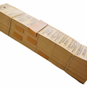 K&ouml;nnte beinhalten: Ein Stapel alter Papiertickets, die mit einer Schnur zusammengebunden sind. Die Tickets sind braun und haben blauen Text. Der Text auf den Tickets lautet "Cincinnati Ohio" und "New York N.Y."
