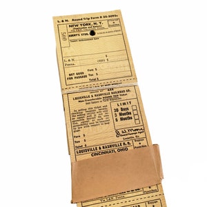 K&ouml;nnte beinhalten: Ein Vintage-Zugticket f&uuml;r eine Rundreise von New York, NY zur Louisville & Nashville Railroad Co. Das Ticket ist auf vergilbtem Papier gedruckt und hat eine G&uuml;ltigkeit von 30 Tagen, 3 Monaten oder 6 Monaten. Das Ticket ist von J.W. Moore, General Passenger Agent, unterzeichnet.