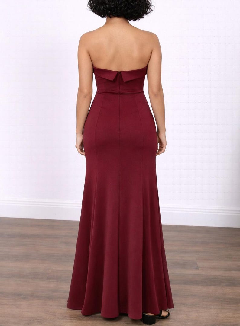 Back view of woman wearing a burgundy strapless Tube Mermaid Maxi Gown on a white background.