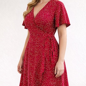 Side view of woman wearing a red floral Ruffle Hem Wrap Mini Dress on a plain background.