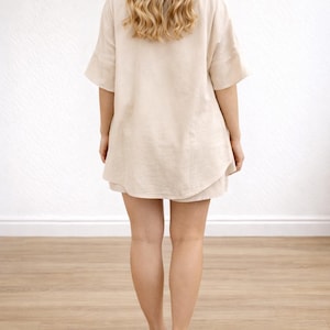 Back view of woman wearing a beige outfit with a Oversized Shirt Jacket and Shorts on a white background.