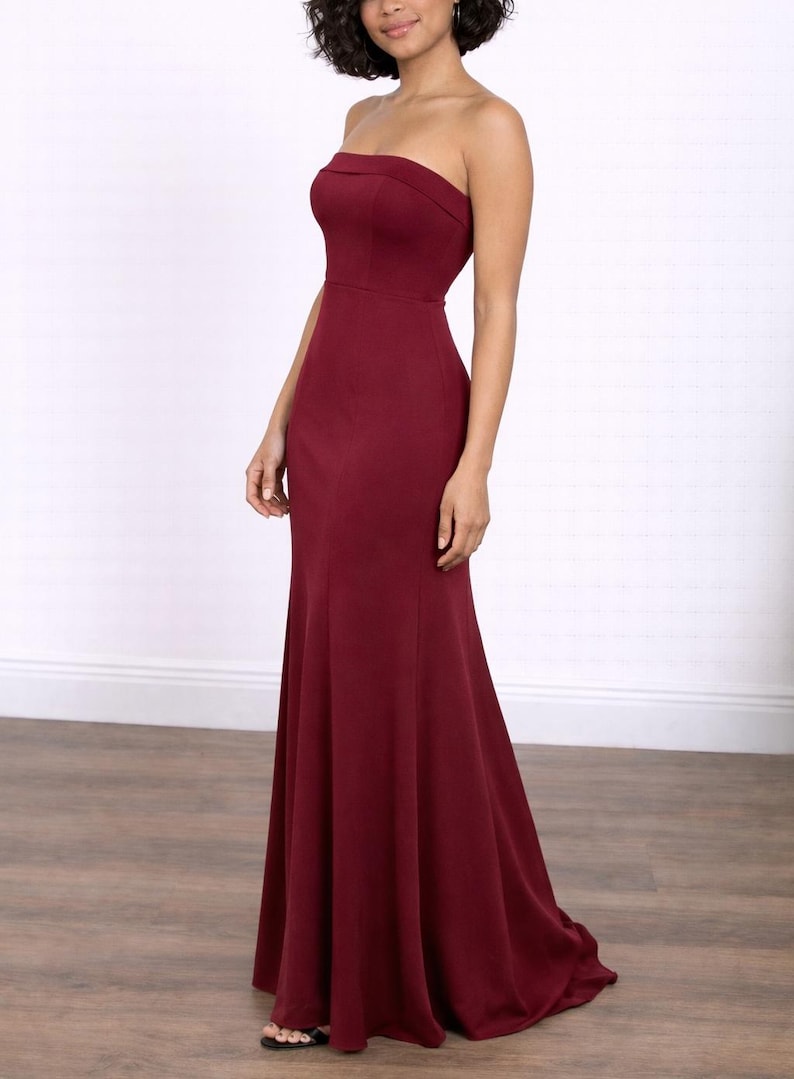 Side view of woman wearing a burgundy strapless Tube Mermaid Maxi Prom Dress on a white background.