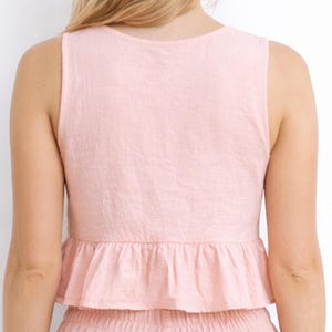Back view of woman wearing a pink Ruffle Hem Crop Top and pants set on a white background.