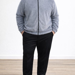 Man wearing a gray zip-up Plus Size Mens Bomber Jacket and black pants on a white background.