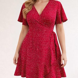 Woman wearing a red floral Ruffle Hem Wrap Mini Dress on a plain background.