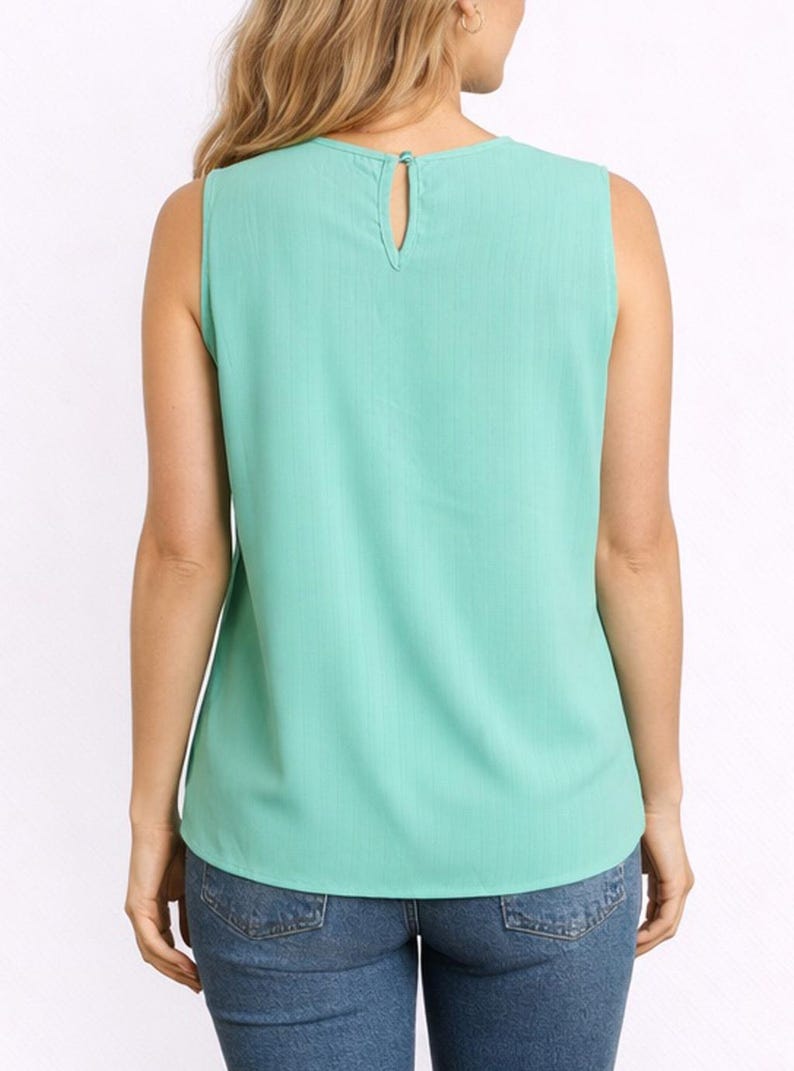 Back view of woman wearing a mint green Keyhole Neckline Sleeveless Top and blue jeans on a white background.