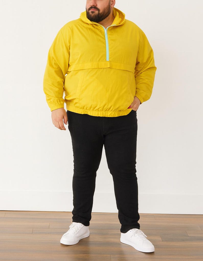 Person wearing a yellow Plus Size Mens Windbreaker Jacket with zipper, black pants, and white shoes on a white background.