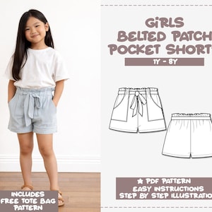 Może przedstawiać: Młoda dziewczyna w jasnoniebieskich spodenkach z paskiem i naszywanymi kieszeniami oraz białym t-shirtem. Obraz zawiera wzór spodenek dla dziewczynek z napisem "GIRLS BELTED PATCH POCKET SHORTS 1Y-8Y". Wzór zawiera proste instrukcje.