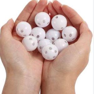 May include: A pair of hands cupping a collection of white plastic balls. Each ball features several small holes. The balls are grouped together, filling the space within the hands. The background is plain white.