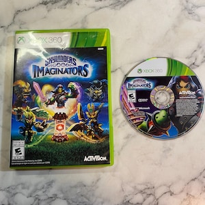 May include: An Xbox 360 game case and disc for Skylanders Imaginators. The green case displays the game title and characters. The disc also features the game title and character art. The game is rated "Everyone 10+".