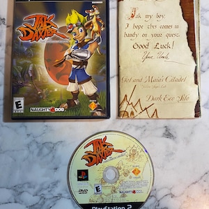 May include: A PlayStation 2 video game case for Jak and Daxter: The Precursor Legacy, a game manual with a handwritten note from an uncle, and the game disc. The cover art features a spiky-haired character and a small creature against a red sun.