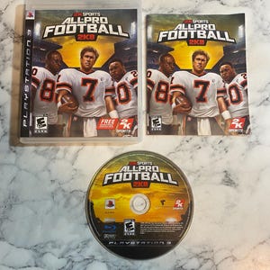 May include: A PlayStation 3 video game set featuring "All-Pro Football 2K8." The set includes the game case, cover art, and the game disc. The cover art features football players in white and orange uniforms. The game disc is gold and black.