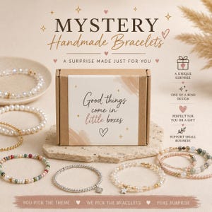 Può includere: Una scatola regalo in cartone marrone con un'etichetta bianca che riporta la scritta Good things come in little boxes, circondata da vari braccialetti di perline con perle, perline metalliche e accenti colorati, disposti su una superficie in pietra.