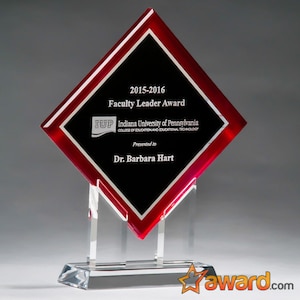 May include: A red and black diamond-shaped glass award with a clear acrylic base. The award features the text "2015-2016 Faculty Leader Award", "Indiana University of Pennsylvania", "College of Education and Educational Technology", and "Presented to Dr. Barbara Hart".
