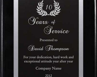 May include: A black plaque with a silver border and a silver laurel wreath with the number 10 in the center. The text "Years of Service" is written in a decorative font. The plaque is presented to David Thompson for his dedication, hard work, and exceptional attitude. The plaque also includes the company name and the year 2012.