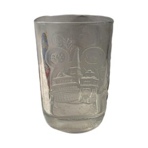 May include: Clear glass tumbler with etched images of buildings and floral designs. The tumbler features a detailed depiction of a building with a tall spire, and the words "Disney World" are etched at the bottom.
