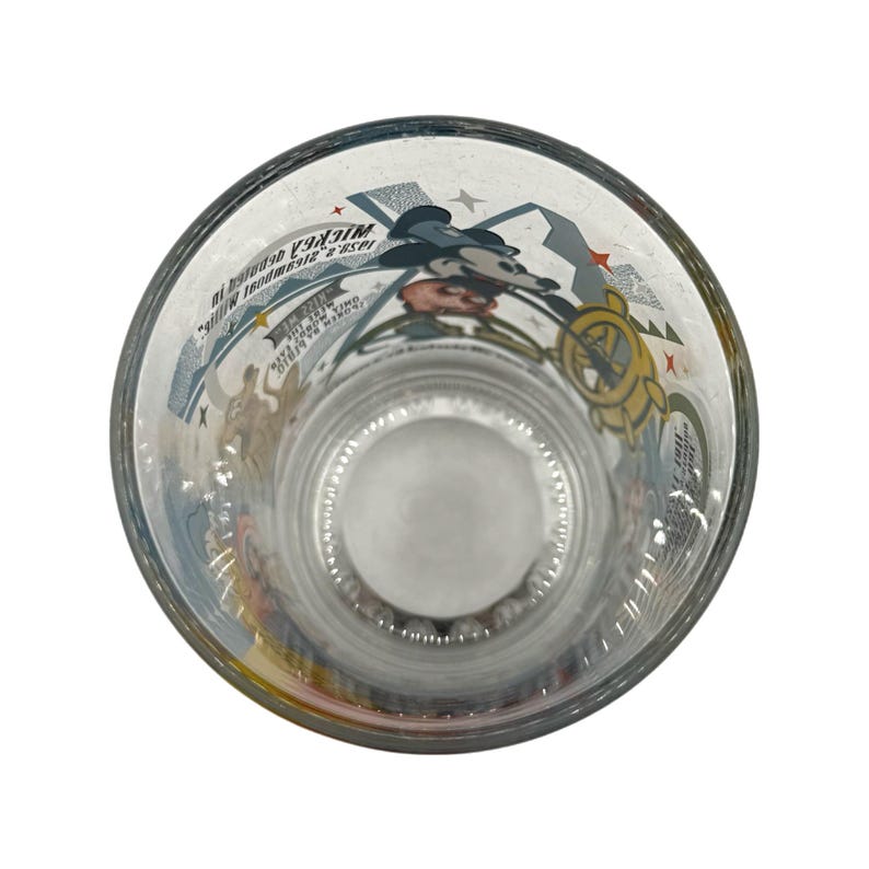 Puede incluir: Vaso transparente con un dise&ntilde;o de dibujos animados con Mickey Mouse y otros personajes. El vaso tiene un borde ancho y una ilustraci&oacute;n detallada en el interior. El dise&ntilde;o incluye estrellas y texto.