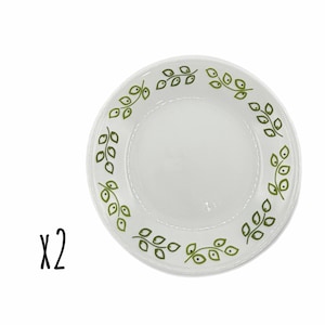 May include: Two white plates with a green leaf design around the rim. The plates have a simple, elegant design, perfect for everyday use. The text "x2" is in the lower left corner.