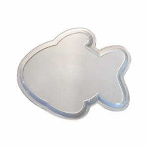 May include: A clear, fish-shaped baking pan. The pan has a smooth, reflective surface and a slightly raised edge. The pan is made of a clear material, and the design is visible from the top.