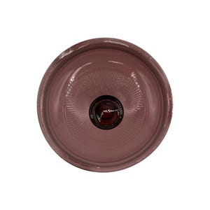 Puede incluir: Vista aérea de un cuenco de cristal color rosa polvoriento con un centro marrón oscuro. El interior del cuenco presenta un patrón radial que emana del centro. El borde del cuenco es ligeramente más oscuro que el interior.