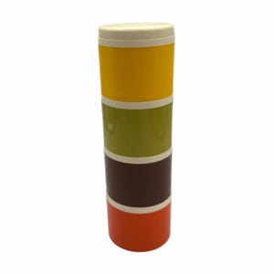 Puede incluir: Un recipiente apilado multicolor con tapa crema. El recipiente está compuesto por cuatro secciones: amarillo, verde oliva, marrón y naranja. Cada sección está separada por una fina banda crema. El recipiente es de forma cilíndrica.