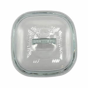 May include: A clear, square glass lid with a rectangular handle. The lid is designed to fit a square dish. The glass is transparent, allowing a clear view of the contents below. The lid's edges are slightly rounded.