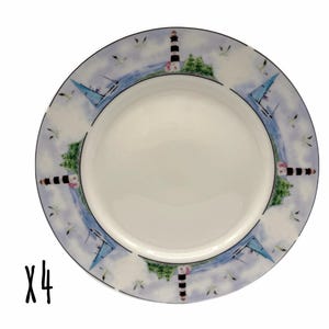 May include: A set of four round ceramic plates featuring a white center and a decorative border. The border displays a repeating nautical scene with black and white striped lighthouses, blue sailboats, green trees, and small birds in flight.