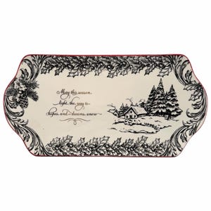 May include: A rectangular ceramic serving platter with a cream-colored base and a thin red rim. The border features a black ink-style illustration of holly leaves and berries. The center displays a winter landscape with a cabin, pine trees, and the text: May this season light the way to hopes and dreams, anew.