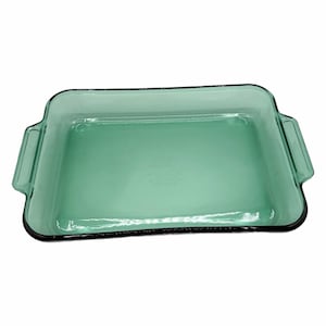 Puede incluir: Una fuente rectangular de vidrio verde claro con borde negro. La fuente tiene dos asas a cada lado y está vacía. El vidrio es transparente, lo que permite ver a través de la fuente. La fuente para hornear es adecuada para su uso en el horno.