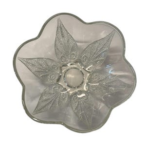 以下が含まれることがあります： 花の形をした透明なガラス製のボウル。ボウルは5つのポイントがあり、それぞれ葉のようなパターンがあります。