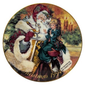May include: A decorative Christmas plate featuring Santa Claus with a young girl. Santa is wearing a red and white suit, holding a rocking horse. The girl is in a green dress. The plate has a gold rim and the text "Christmas 1994".