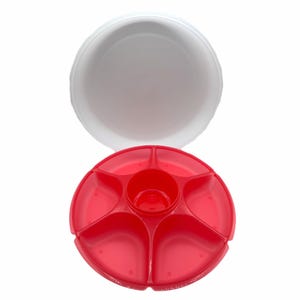 Peut inclure: Un plateau de service en plastique rouge avec cinq compartiments et un support central pour trempette, associé à un couvercle blanc. Le plateau est conçu pour les collations ou les apéritifs.