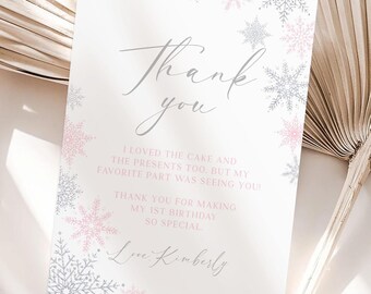 Puede incluir: Una tarjeta de agradecimiento blanca con un diseño de copo de nieve rosa y gris. La tarjeta dice "Gracias" en cursiva e incluye el texto "Me encantó el pastel y los regalos también, pero mi parte favorita fue verte. ¡Gracias por hacer mi primer cumpleaños tan especial! Con cariño, Kimberly."