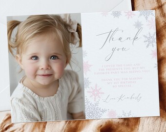 Puede incluir: Una tarjeta de agradecimiento con una foto de una niña pequeña con cabello rubio y ojos azules. La tarjeta tiene un diseño de copo de nieve rosa y gris y el texto "Gracias. Me encantó el pastel y los regalos también, pero mi parte favorita fue verte! Gracias por hacer mi primer cumpleaños tan especial. Con cariño, Kimberly."