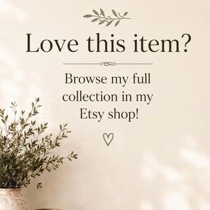 May include: A beige wall graphic with dark brown text reading Love this item? Browse my full collection in my Etsy shop! above a small heart icon. Below the text, a rustic ceramic vase with green foliage sits on two stacked books.