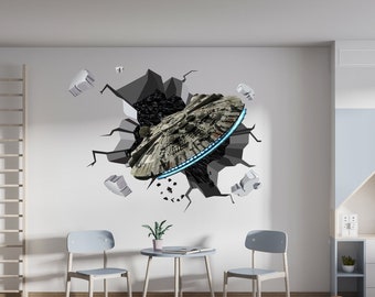 Puede incluir: Una pared blanca con una calcomanía de pared 3D de una nave espacial rompiendo la pared. La nave espacial es gris y negra con una luz azul alrededor. Hay dos sillas grises y una mesa pequeña con una planta encima frente a la pared. Hay una estantería blanca con un oso de peluche en el estante a la derecha de la pared.