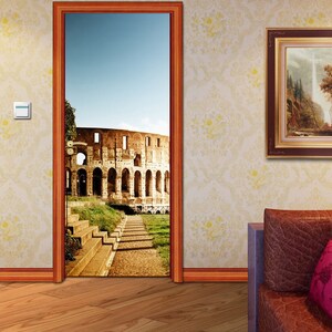 May include: A door with a photograph of the Colosseum in Rome, Italy. The door is open and the photo shows a path leading up to the Colosseum. There is a sofa with cushions in the room.