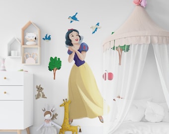 Op de afbeelding: Een witte muur met een wit hemelbed met een wit en roze baldakijn. Er zijn verschillende muurstickers met Sneeuwwitje, vogels, bomen en dieren. Er is een witte commode met lades en een wit tapijt op de vloer.