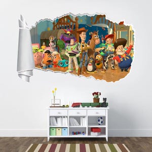May include: A colourful wall decal featuring characters from the Toy Story movie. The decal shows Woody, Buzz Lightyear, Jessie, and other characters from the film. The decal is designed to look like it is breaking through the wall.
